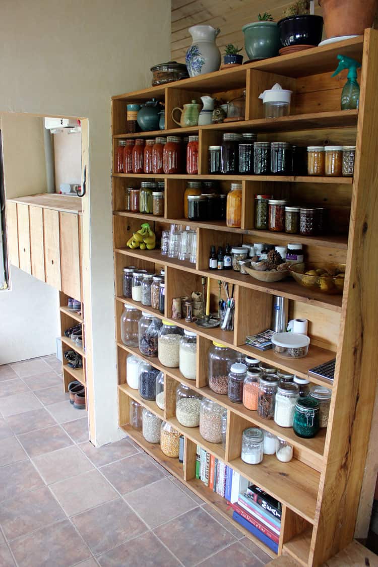 A handmade custom built pantry shelf organized with jars.