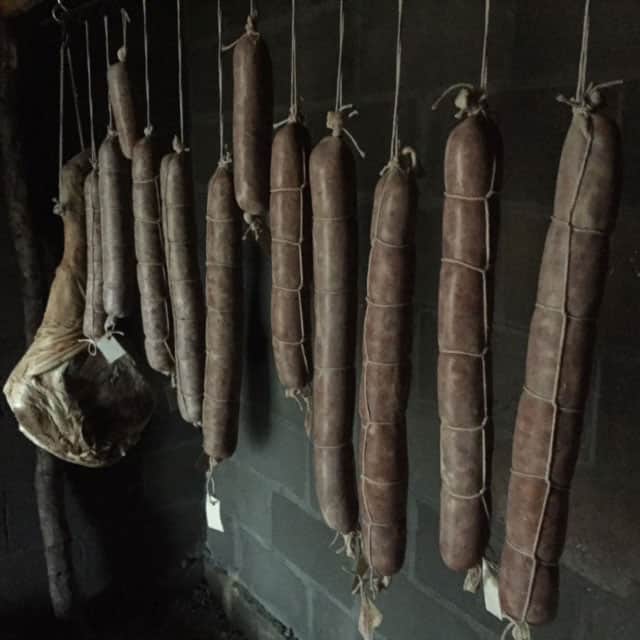 Homegrown and homemade salami and prosciutto hang in our root cellar | Homestead Honey