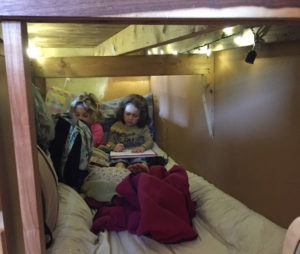 Living with kids in a tiny house requires creative space utilization. Here our kids are hanging out in what we call our 